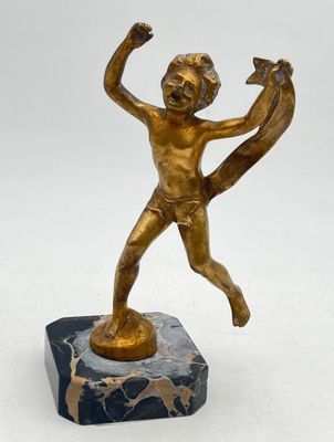 bronze figurine of a boy holding a dog on a marble base