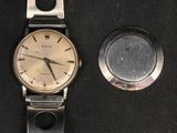 a silver watch and a silver watch on a black surface