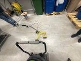 a man standing next to a lawn mower in a garage
