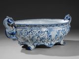 un bol bleu et blanc richement décoré, sur lequel figurent deux oiseaux
