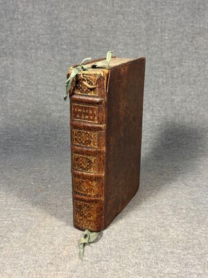 an old book sitting on top of a table next to a gray background