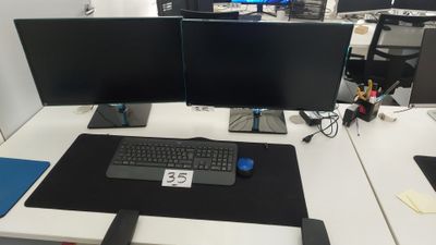 un bureau équipé de deux écrans et d'un clavier