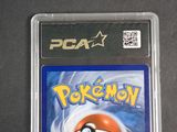 the pokemon card is in a plastic case on a table