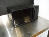 a microwave sitting on top of a metal table