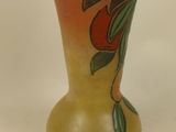 a yellow vase with a design on it on a white surface