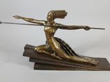 bronze statue of a woman with a bow and arrow on a wooden base