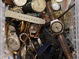 un panier rempli de montres et des montres posées sur une table