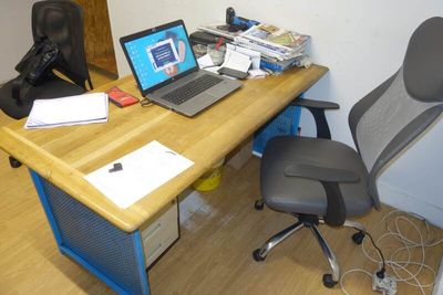 a desk with a laptop and a chair next to it