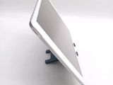 a tablet computer sitting on a stand on a white surface