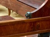 a wooden bench that has a lion head on it
