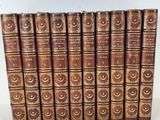 a set of six old books with brown covers on a white surface