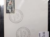 an envelope with two stamps on it sitting on top of a piece of paper
