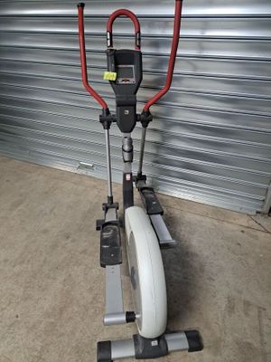 un vélo d'appartement dans un garage, avec un guidon rouge