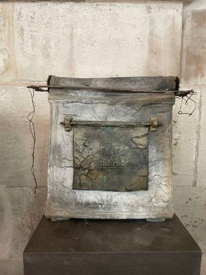 a metal box with a sign on it on a pedestal