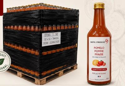 une bouteille de sauce tomate à côté d'une caisse de tomates