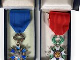 two medals are in a box with a ribbon around them