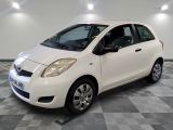 la petite voiture blanche est garée sur un carrelage à carreaux