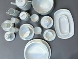 a lot of white dishes and cups on the table