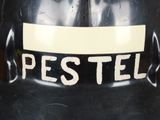 a sign on the back of a black fire hydrant that says pestel