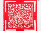 une écharpe carrée rouge et blanche ornée d'oiseaux et de fleurs