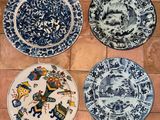 quatre assiettes bleues et blanches ornées de motifs, posées sur un sol carrelé