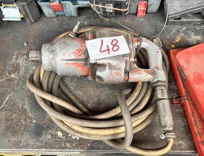 une perceuse et un tuyau d'arrosage posés sur une table dans un garage