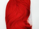 a close up of a red wig on a white surface
