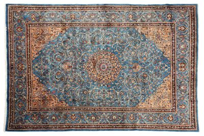 un tapis bleu orné d'un motif en médaillon sur fond blanc