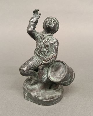 a statue of a man sitting on top of a barrel
