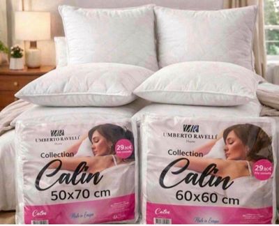 two boxes of calin pillows on a bed in a bedroom