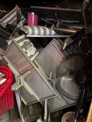un tas d'objets divers et un ventilateur dans un garage