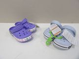 Deux paires de Crocs sont posées sur une table blanche.