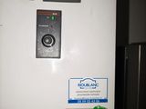 a white refrigerator with a green button on it