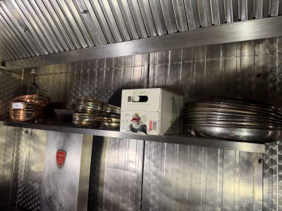many plates and pans on the shelf in the kitchen