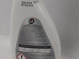 a close up of a bottle of liquid on a white surface