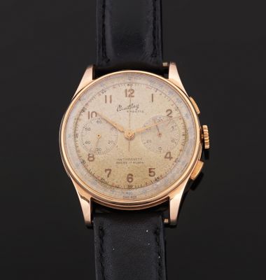 a gold plated wrist watch with a black leather strap