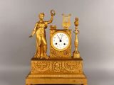 a gold clock with a statue on top of it