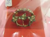 une broche en or ornée de feuilles et de perles