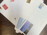 several envelopes of different sizes and colors on a wooden table