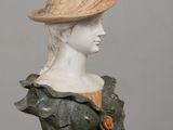 marble bust of a woman with a hat on her head