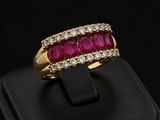 a close up of a gold ring with a ruby and diamond band