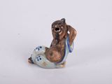 une petite figurine représentant un chien posée sur une surface blanche