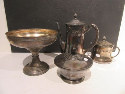 une théière en argent et un bol en argent posés sur une table