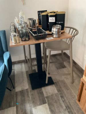 une petite table sur laquelle se trouve une cafetière, dans un coin de la pièce