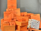 plusieurs sacs de courses orange empilés les uns sur les autres sur une table