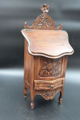 an old wooden cabinet with carvings on the front and a drawer on the back