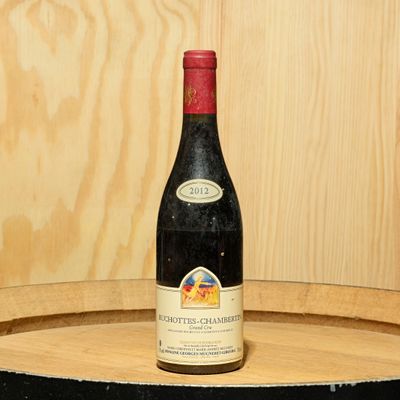 une bouteille de vin posée sur un tonneau