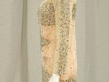 a mannequin dress with sequins and beads on a mannequin stand