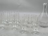 many glasses and a decanter sitting on a table