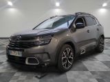 Une Citroën grise est garée dans une pièce au sol carrelé